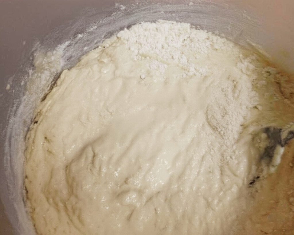 Massa de pão de arroz sendo despejada em uma forma untada.